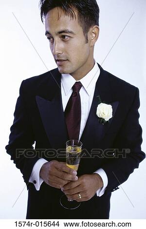 Young man holding a champagne flute View Large Photo Image Picture - Young man holding a champagne flute. Fotosearch