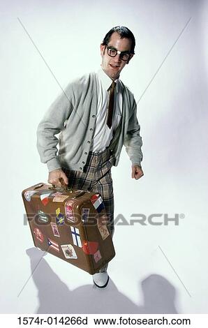 Young man holding a suitcase View Large Photo Image Stock Image - Young man holding a suitcase. Fotosearch
