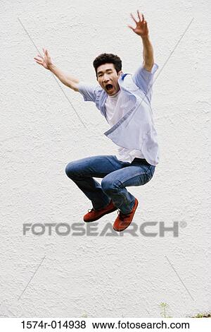 Stock Photo - Young man jumping with his arms outstretched. Fotosearch