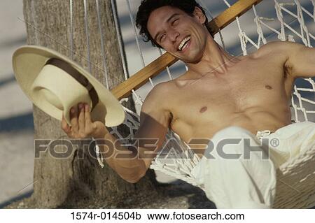 Stock Image - Young man lying in a hammock. Fotosearch