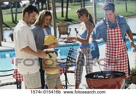 Young man serving hot dogs at a barbecue View Large Photo Image Stock Image - Young man serving hot dogs at a barbecue. Fotosearch