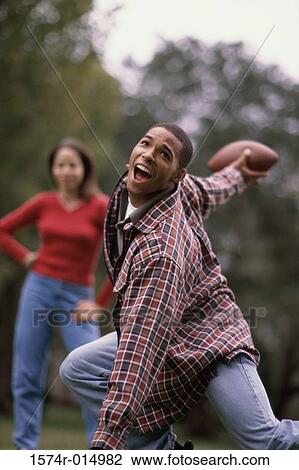 Stock Image - Young man throwing a football. Fotosearch