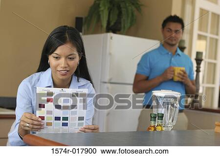 Stock Image - Young woman choosing color from a color swatch. Fotosearch