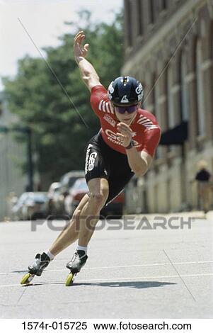 Stock Photography - Young woman inline skating on road. Fotosearch