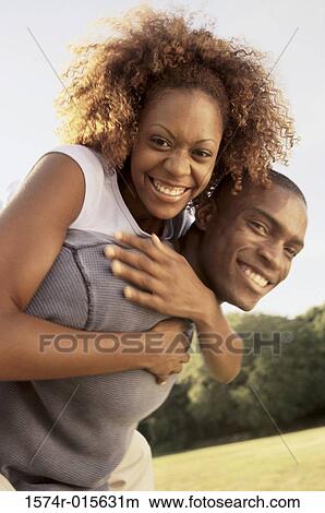Young woman riding piggyback on a young man View Large Photo Image Picture - Young woman riding piggyback on a young man. Fotosearch