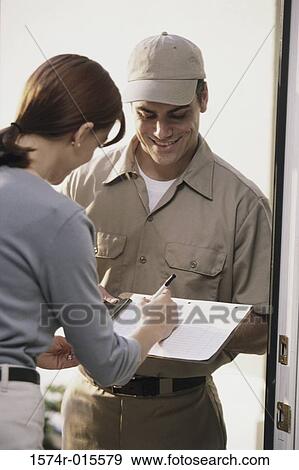 Stock Photo - Young woman signing for a delivery. Fotosearch