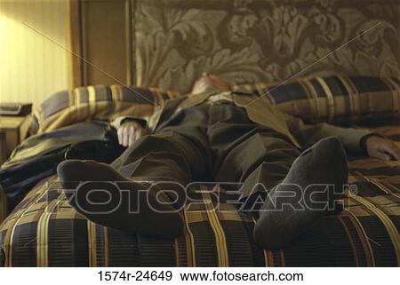 Businessman lying on a bed View Large Photo Image Stock Photo - Businessman lying on a bed. Fotosearch