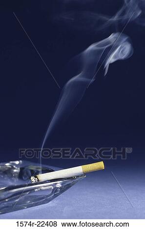 Cigarette burning in an ashtray View Large Photo Image Stock Photo - Cigarette burning in an ashtray. Fotosearch