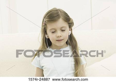 Stock Photo - Close-up of a girl wearing headphones and listening to music. Fotosearch