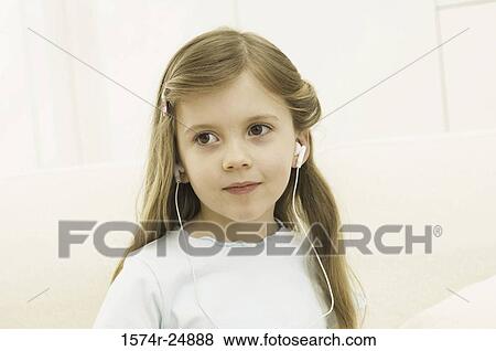 Close-up of a girl wearing headphones and listening to music View Large Photo Image Stock Photo - Close-up of a girl wearing headphones and listening to music. Fotosearch