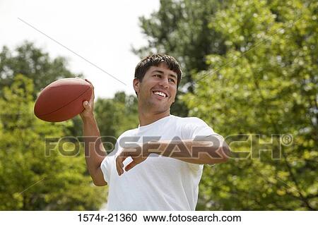 Close-up of a mid adult man throwing a football View Large Photo Image Stock Image - Close-up of a mid adult man throwing a football. Fotosearch