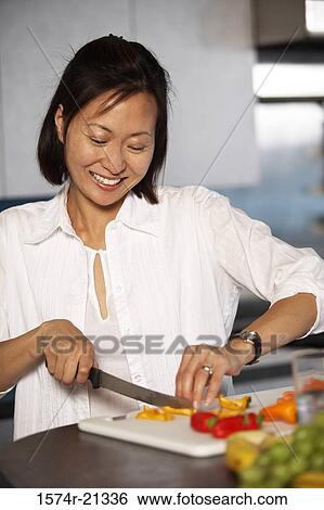 Close-up of a mid adult woman cutting a carrot on a cutting board View Large Photo Image Stock Photograph - Close-up of a mid adult woman cutting a carrot on a cutting board. Fotosearch