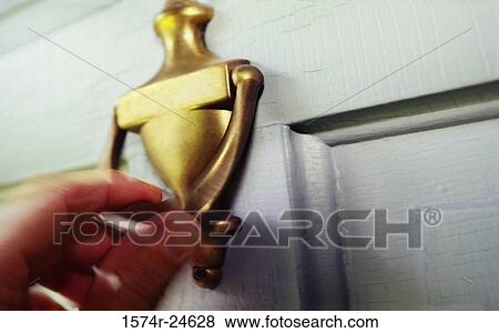 Stock Photo - Close-up of a person's hand knocking on a door. Fotosearch