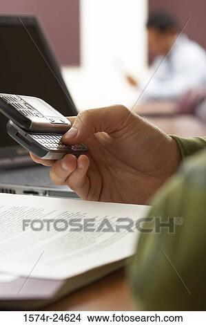 Close-up of a person's hand using a mobile phone View Large Photo Image Picture - Close-up of a person's hand using a mobile phone. Fotosearch