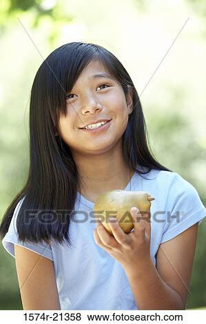 Close-up of a teenage girl eating a pear View Large Photo Image Stock Photo - Close-up of a teenage girl eating a pear. Fotosearch