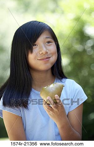 Close-up of a teenage girl eating a pear View Large Photo Image Stock Photograph - Close-up of a teenage girl eating a pear. Fotosearch