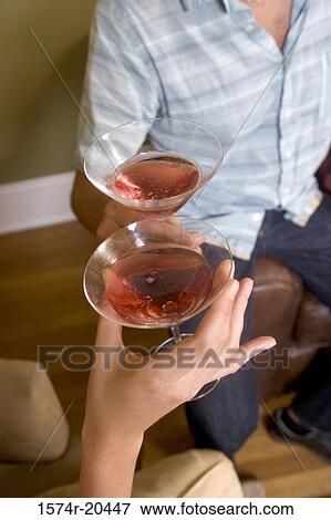 Close-up of a young couple toasting with drinks View Large Photo Image Stock Photo - Close-up of a young couple toasting with drinks. Fotosearch