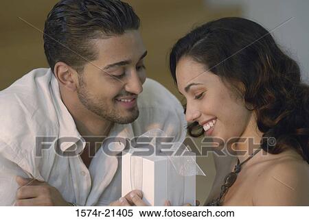 Close-up of a young man giving a gift to a young woman View Large Photo Image Stock Photography - Close-up of a young man giving a gift to a young woman. Fotosearch