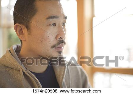 Close-up of a young man looking serious View Large Photo Image Stock Photo - Close-up of a young man looking serious. Fotosearch