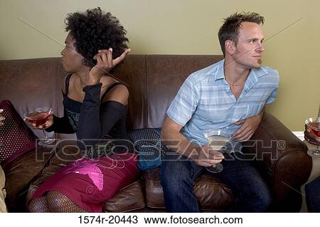 Close-up of a young man sitting with a young woman on a couch at a party View Large Photo Image Stock Image - Close-up of a young man sitting with a young woman on a couch at a party. Fotosearch