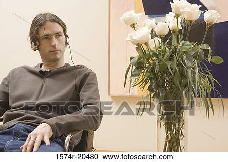 Close-up of a young man wearing headphones and listening to music View Large Photo Image Stock Image - Close-up of a young man wearing headphones and listening to music. Fotosearch