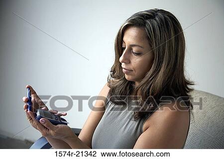 Close-up of a young woman holding a glaucometer View Large Photo Image Stock Image - Close-up of a young woman holding a glaucometer. Fotosearch