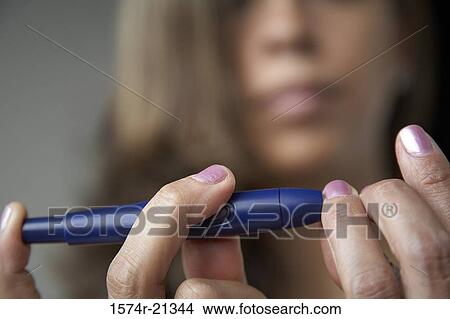 Close-up of a young woman taking a blood sample from her finger with a glaucometer View Large Photo Image Picture - Close-up of a young woman taking a blood sample from her finger with a glaucometer. Fotosearch