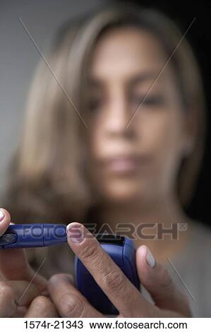 Close-up of a young woman taking a blood sample from her finger with a glaucometer View Large Photo Image Stock Image - Close-up of a young woman taking a blood sample from her finger with a glaucometer. Fotosearch