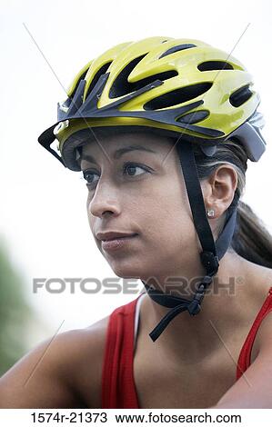 Stock Image - Close-up of a young woman wearing a cycling helmet. Fotosearch