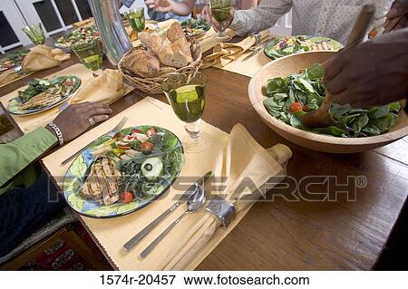 Four people at a dining table View Large Photo Image Stock Photo - Four people at a dining table. Fotosearch