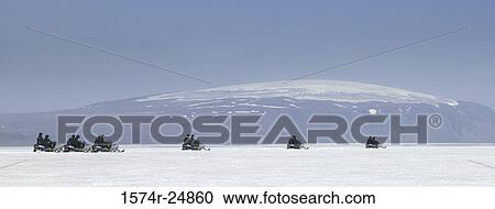 Stock Image - Group of snowmobilers on a snow covered landscape, Langjokull Glacier, Eiriksjokull Glacier, Iceland. Fotosearch