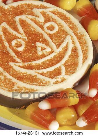 Stock Image - High angle view of a decorated Halloween cookie with candy corn. Fotosearch