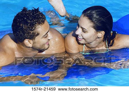 High angle view of a young couple leaning on a pool raft in a swimming pool View Large Photo Image Stock Photo - High angle view of a young couple leaning on a pool raft in a swimming pool. Fotosearch