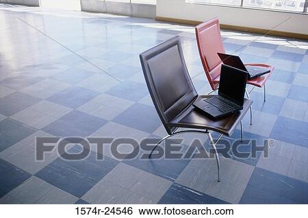 High angle view of two laptops in two chairs View Large Photo Image Stock Photograph - High angle view of two laptops in two chairs. Fotosearch