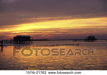 Stock Image - House on the ocean at sunset. Fotosearch