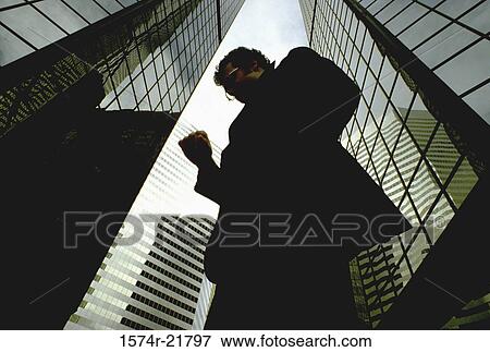 Low angle view of a businessman looking at his wristwatch View Large Photo Image Stock Photo - Low angle view of a businessman looking at his wristwatch. Fotosearch