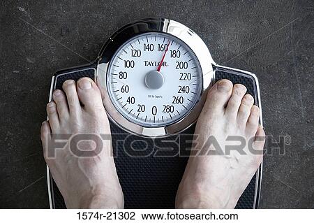 Low section view of a person standing on a weighing scale View Large Photo Image Stock Image - Low section view of a person standing on a weighing scale. Fotosearch