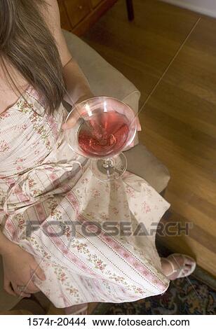 Picture - Low section view of a young woman holding a drink. Fotosearch