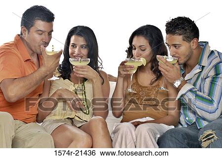 Mid adult couple and a young couple sitting on a couch and drinking margaritas View Large Photo Image Stock Photograph - Mid adult couple and a young couple sitting on a couch and drinking margaritas. Fotosearch