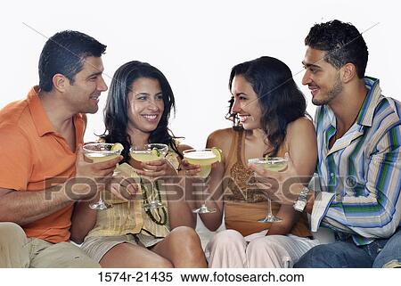 Mid adult couple and a young couple sitting on a couch and holding margaritas View Large Photo Image Stock Photography - Mid adult couple and a young couple sitting on a couch and holding margaritas. Fotosearch