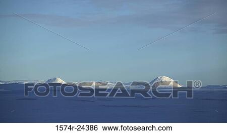 Stock Photograph - Panoramic view of a snow covered landscape with mountains in the background, Mount Nyrdri Haganga, Mount Sydri Haganga, Iceland. Fotosearch