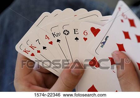 Stock Photograph - Person's hand holding playing cards. Fotosearch