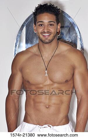 Portrait of a bare chested young man smiling with his hands in his pockets View Large Photo Image Stock Image - Portrait of a bare chested young man smiling with his hands in his pockets. Fotosearch