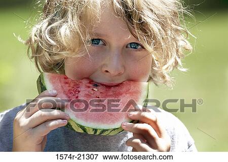Portrait of a boy eating a slice of watermelon View Large Photo Image Stock Photo - Portrait of a boy eating a slice of watermelon. Fotosearch