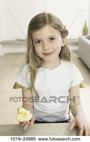 Portrait of a girl holding a half eaten apple View Large Photo Image Stock Photo - Portrait of a girl holding a half eaten apple. Fotosearch