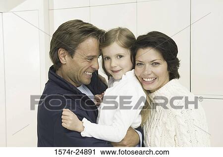 Stock Image - Portrait of a girl smiling with her parents. Fotosearch
