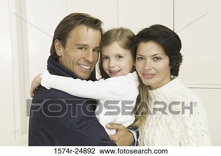 Stock Image - Portrait of a girl smiling with her parents. Fotosearch