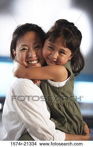 Portrait of a mid adult woman hugging her daughter View Large Photo Image Picture - Portrait of a mid adult woman hugging her daughter. Fotosearch