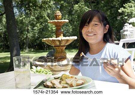 Picture - Portrait of a teenage girl having breakfast. Fotosearch