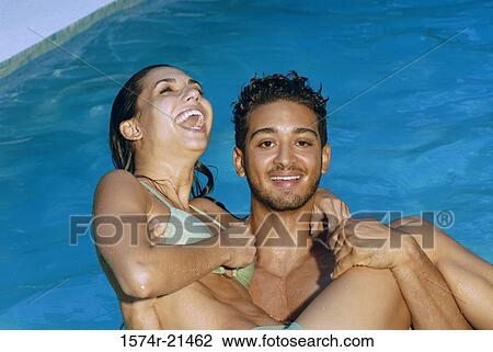 Portrait of a young man carrying a young woman in a swimming pool View Large Photo Image Stock Image - Portrait of a young man carrying a young woman in a swimming pool. Fotosearch